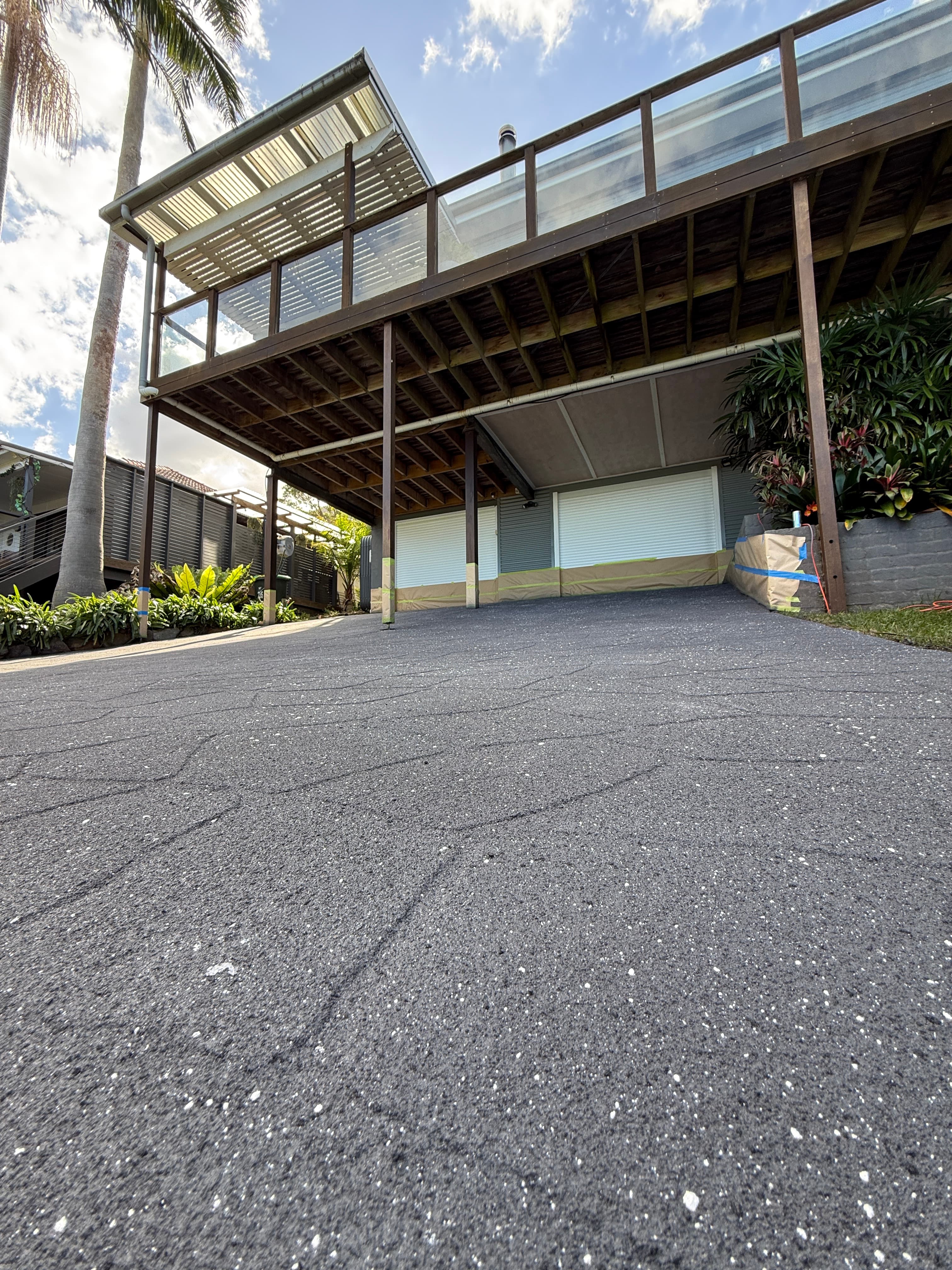 A freshly coated concrete driveway under a carport at a Superior Coating job